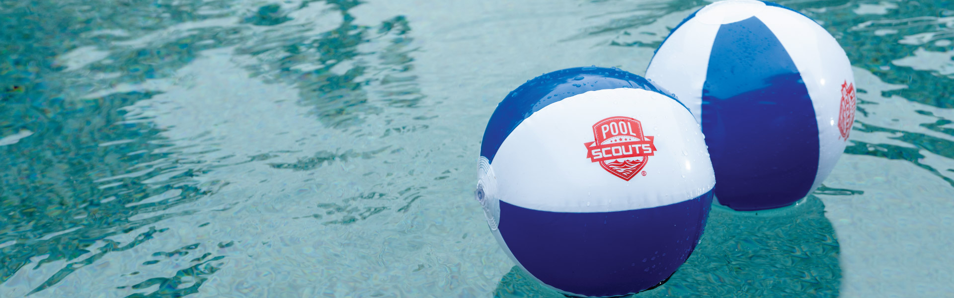 Beach balls with Pool Scouts logo in pool