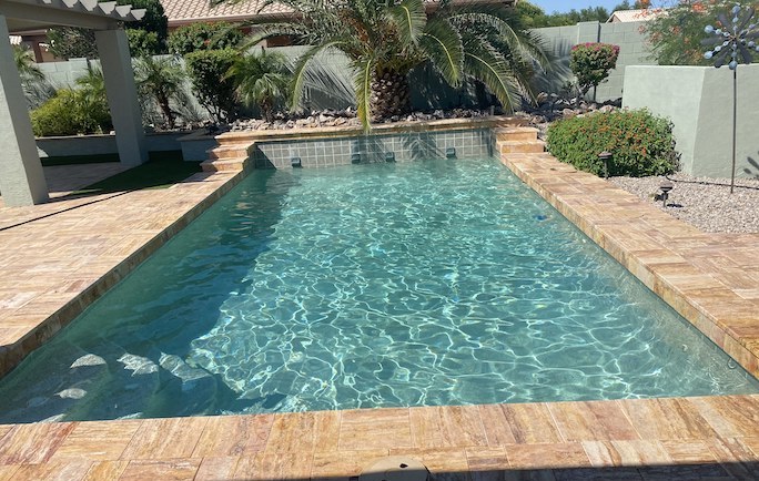 Clean swimming pool in backyard in Chandler, AZ on sunny day