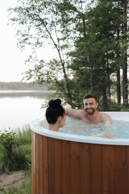 Couple enjoying hot tub in the winter after hot tub cleaning service by Pool Scouts