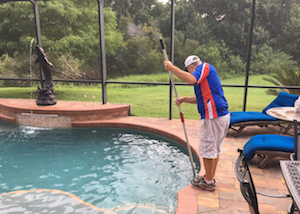 Pool tech cleaning a pool with a screen protector