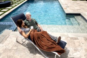 Happy couple next to a clean pool in colder weather