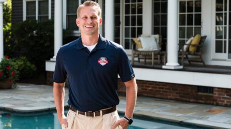 Pool Scouts technician smiling next to a clean pool