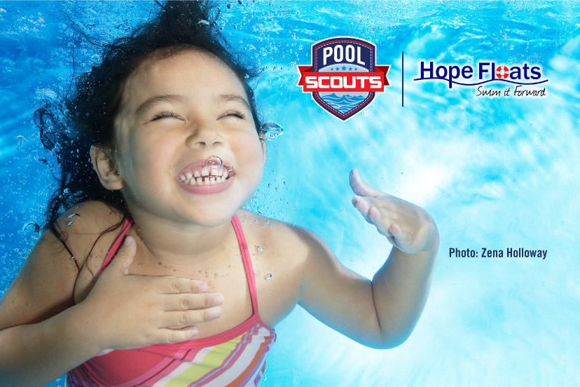 Little girl smiling underwater after receiving swim lessons from Hope Floats Foundation