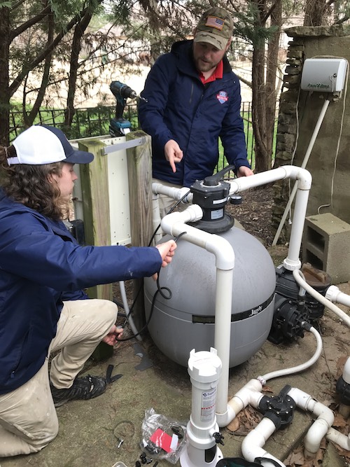 Two Pool Scouts techs performing an automatic chlorinator installation