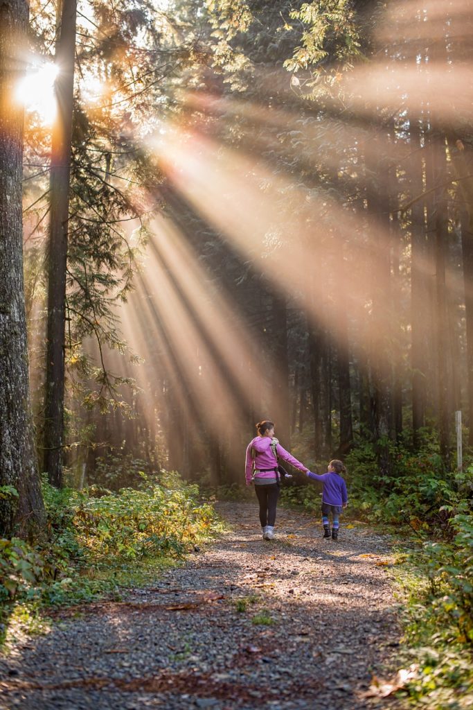 Mother and daughter hiking on a trail in the woods