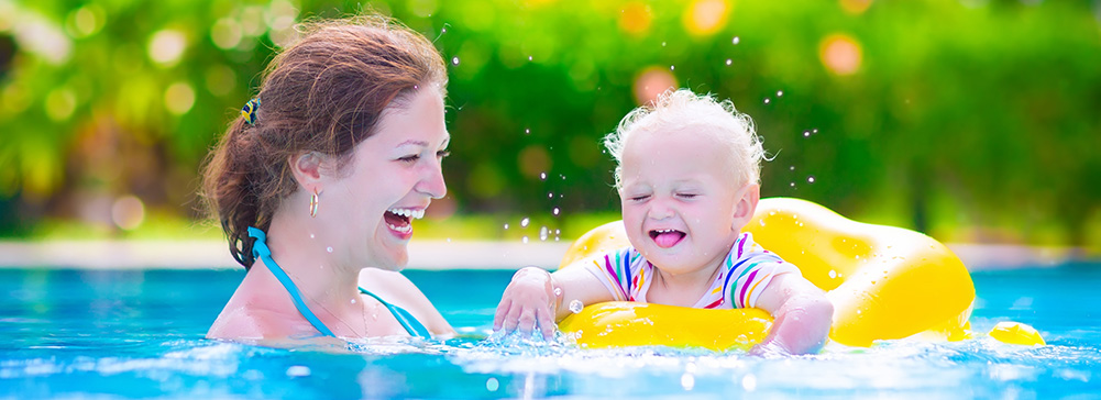 Mom with baby in a floatie in the pool