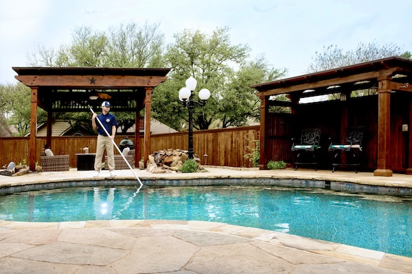 Pool technician cleaning a customer's pool