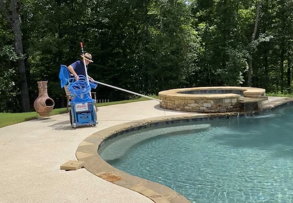 Pool Scouts owner cleaning a swimming pool