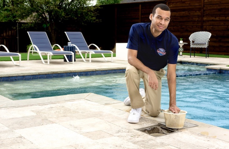 Pool technician cleaning out a skimmer basket