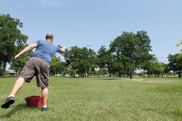 Man throwing a disc at a disc golf course