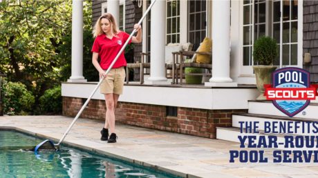 Pool technician skimming leaves from pool