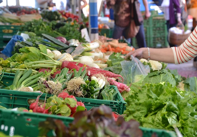 Person picking up produce at a farmers market in Anderson, SC
