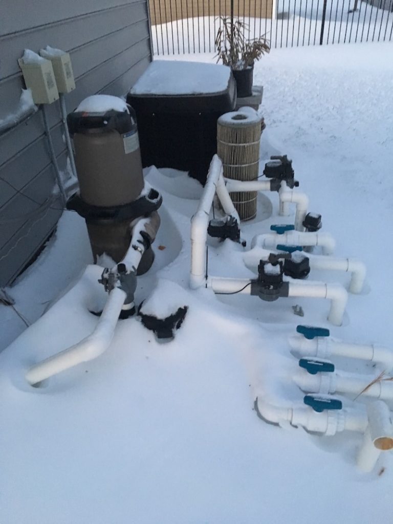 Image of pool pump buried in snow next to house
