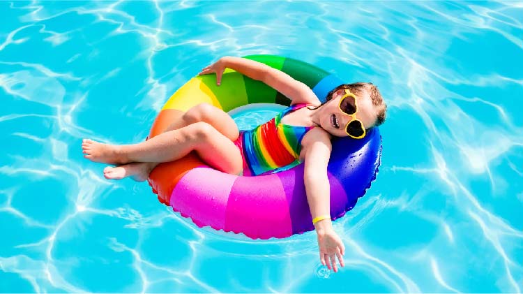 Little girl relaxing in a pool float in the swimming pool