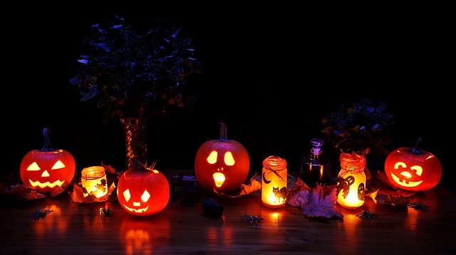 Row of carved pumpkins lit up at night